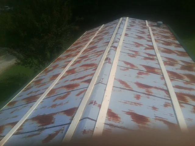Rusted metal roof panels with new wood purlins before replacement — Storm Damage Roof Repair in Zanesville by Roofing Brothers