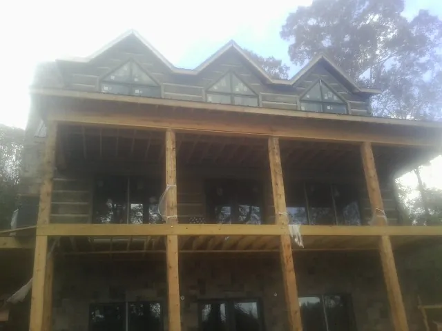 Dormers and porch framing on a large log home under construction — Roof Coating work by our crew in Zanesville