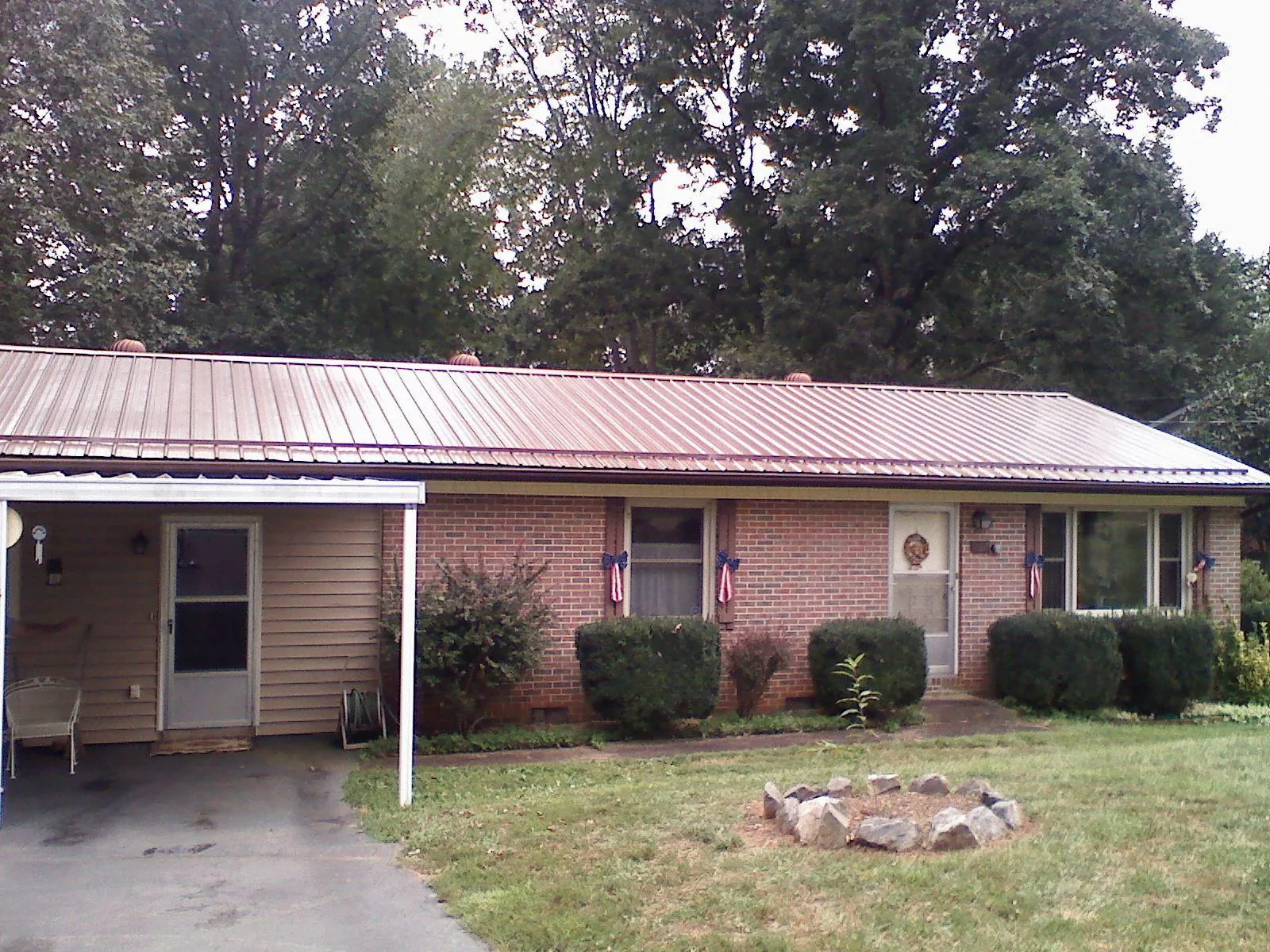 Bronze metal roof and carport on a brick ranch home — Roof Repair work by our crew in Zanesville