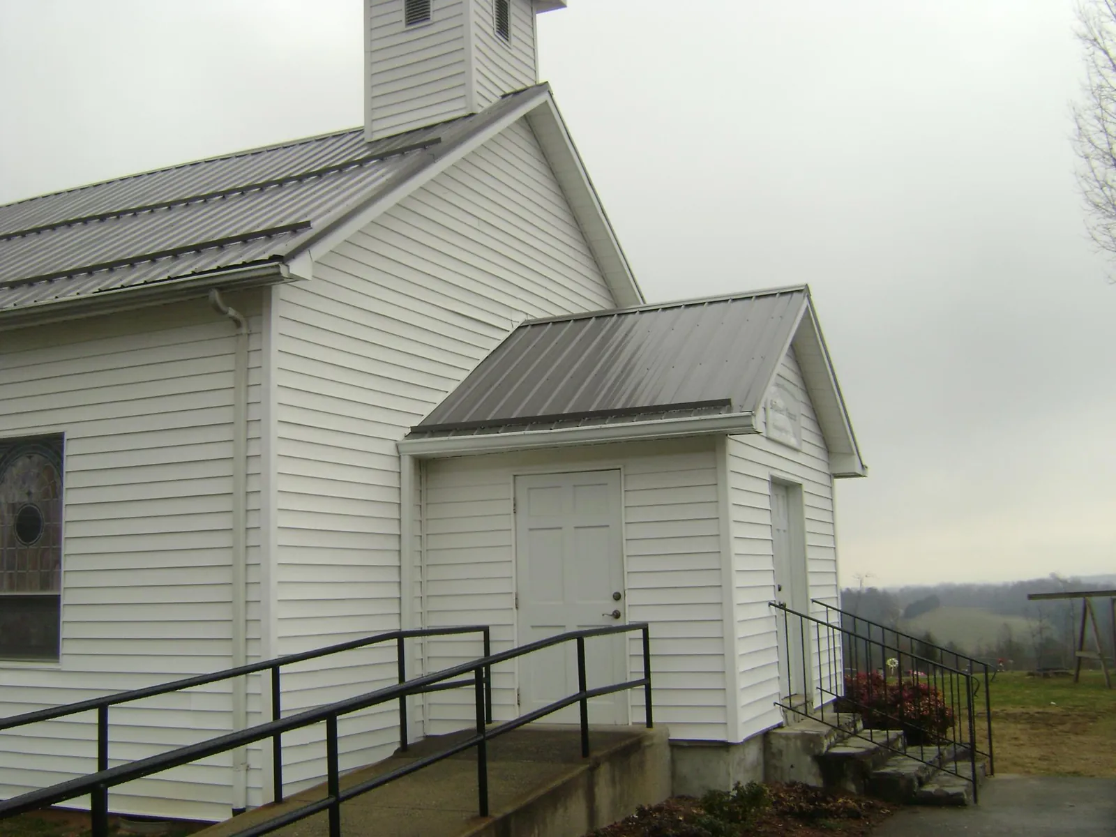 Gray metal roof on a white clapboard church with a steeple in Zanesville